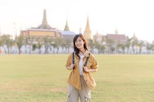 A Traveler Asian woman in her 30s exploring Wat Pra Kaew. From stunning architecture to friendly locals, she cherishes every moment, capturing it all in her heart and camera for years to come. photo