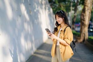 Traveler young asian woman in her 30s explores Bangkok with her smartphone. Capture the beauty and freedom of solo travel with her. photo