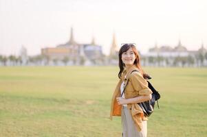 A Traveler Asian woman in her 30s exploring Wat Pra Kaew. From stunning architecture to friendly locals, she cherishes every moment, capturing it all in her heart and camera for years to come. photo