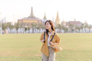 A Traveler Asian woman in her 30s exploring Wat Pra Kaew. From stunning architecture to friendly locals, she cherishes every moment, capturing it all in her heart and camera for years to come. photo