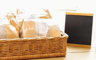 Basket with Wrapped Goods and Blank Chalkboard, grocery concept photo