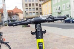 Electric scooter handlebars close-up in urban setting, transportation, technology concept photo