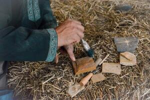 Hands of a master mason at a medieval festival in Portugal, working with stone using tools. Concept for reconstructing historical crafts photo