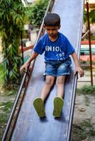 Asian boy doing routine exercise in society park during the morning time. Cute little kid exercise and gym to keep himself fit for life. Child exercise outdoor shoot photo