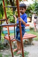 Asian boy doing routine exercise in society park during the morning time. Cute little kid exercise and gym to keep himself fit for life. Child exercise outdoor shoot photo