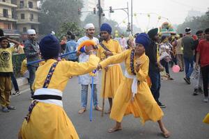 Delhi, India, August 15, 2024 - Sikhs display gatka and martial arts during annual Nagar Kirtan, Traditional, procession on account of birthday of Guru Nanak Dev ji, Nagar Kirtan in East Delhi area photo