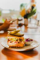 Cheese sandwich with pickles on a plate in cafe. photo