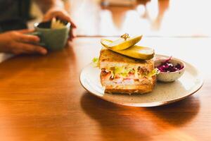 Cheese sandwich with pickles on a plate in cafe. photo