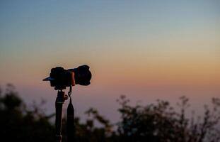 Photographer sets up a camera to capture the view of a traveler, a nature lover, peace and relaxation in nature. photo