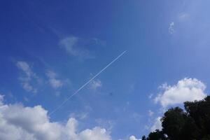 A plane flying through the sky with a contrail photo