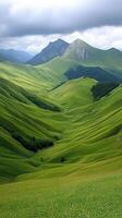 A green field with hills and mountains in the background photo