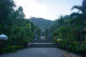 A pathway leading to a temple with a statue of a man photo