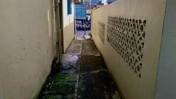 narrow alley with walls and motorbikes at the end. photo