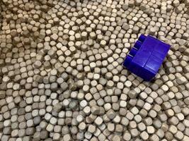 a piece of blue plastic lying on top of a pile of white cubes. suitable for use as a background photo