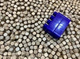 a piece of blue plastic lying on top of a pile of white cubes. suitable for use as a background photo