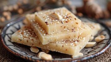 Close-up of traditional Indian sweet Badam Katli, barfi garnished with sesame seeds and nuts. A delicious almond-based dessert with a soft, grainy texture, perfect for festive occasions or snacks photo