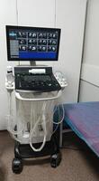 Vertical image of Ultrasound equipment in medical examination room showing monitor with scan, control console and transducers. The setup is prepared for diagnostic tests in a healthcare setting. photo