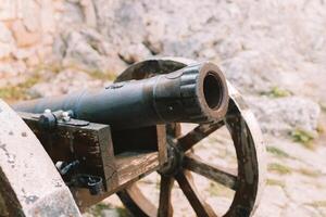 Cannon on a carriage located on a white stone pedestal near the arsenal building in Mirow Castle. Sites of Poland. Architecture of World Tourism. photo