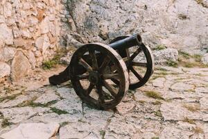 Cannon on a carriage located on a white stone pedestal near the arsenal building in Mirow Castle. Sites of Poland. Architecture of World Tourism. photo