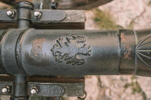 Cannon on a carriage located on a white stone pedestal near the arsenal building in Mirow Castle. Sites of Poland. Architecture of World Tourism. photo