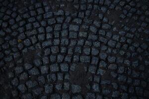 Square pavement paved with gray cobblestones rectangles texture. Cobble stone walkway photo