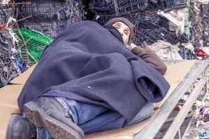 homeless man sleeps in the waste on a wire mesh of bed photo