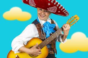 sonriente medio Envejecido mujer vestido como mexicano Mariachi con sombrero jugando un clásico guitarra posando en antecedentes con nubes foto