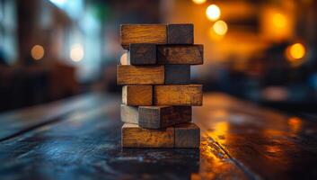 A stack of wooden blocks on a table. The blocks are arranged in a pyramid shape. Concept of stability and balance, as the blocks are stacked in a way that they do not topple over photo