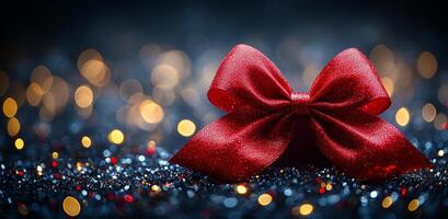 A vibrant red bow sits elegantly on a dark, shimmering surface adorned with soft lights, creating a festive atmosphere. photo