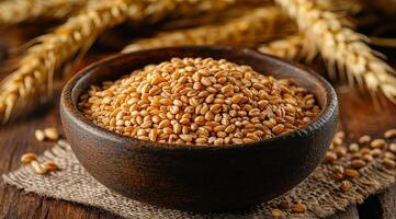 Grains fill a rustic wooden bowl on burlap with golden wheat stalks in the background, highlighting a bountiful harvest. photo