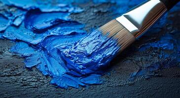 Blue paint on canvas with a brush. The brush distributes vibrant blue paint across a textured surface, capturing the essence of artistic creation and expression. photo