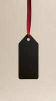 Rectangular black blank paper tag label price tag with hanging rope isolated pink photo