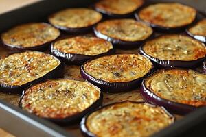 Slices of eggplant baking with thyme on a baking sheet photo