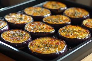 Slices of eggplant baking with thyme on a baking sheet photo