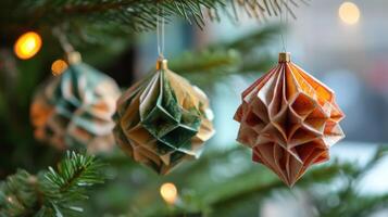 Three Paper Ornaments Hanging on a Christmas Tree Branch photo