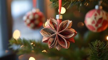 Red and White Paper Star Christmas Ornament Hanging on a Christmas Tree photo