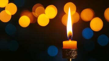 A Single Candle Burning Brightly Against a Background of Blurred Lights photo