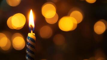 A Single Birthday Candle with a Blurred Background of Yellow Lights photo