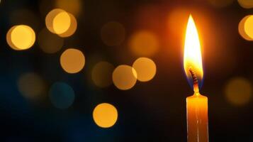 A Single Candle Flame with Defocused Lights in the Background photo