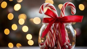 Candy Canes and a Red Bow in a Glass Jar with a Bokeh Background photo