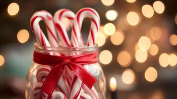 Candy Canes in Glass Jar with Red Ribbon and Festive Lights photo