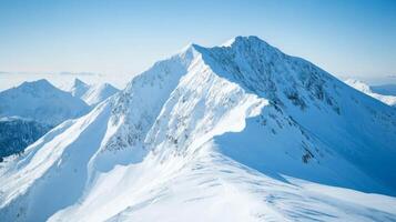 Snow-Covered Mountain Ridge with a Clear Blue Sky photo