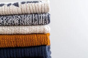 Folded wool sweaters with textured knitting patterns in various colors photo