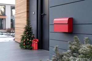 Red mailbox on a wall with a Christmas tree in the background photo