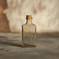 An empty glass bottle sitting on a table photo