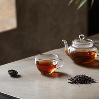 A teapot and a cup of tea sit on a table photo