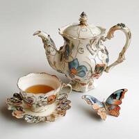 A tea pot and a butterfly on a table photo