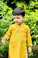 A young boy in yellow kurta and pants photo