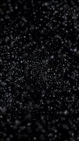 Blizzard winter snowfall particles loop animation vertical background, moving through heavy snowfall, white snow dust particle mist spray loop animated effect on black vertical background video