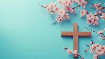 A wooden cross surrounded by delicate blossoms on a vibrant blue background photo